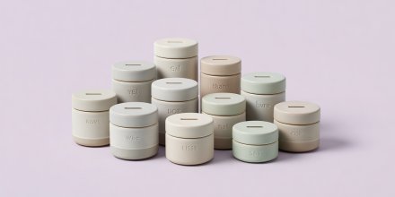 Soft-lit 3D render of labeled ceramic coin containers on a clean pale lilac background